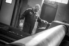 Karl-Erik Hoberg riktar en produkt vid en valsmaskin.